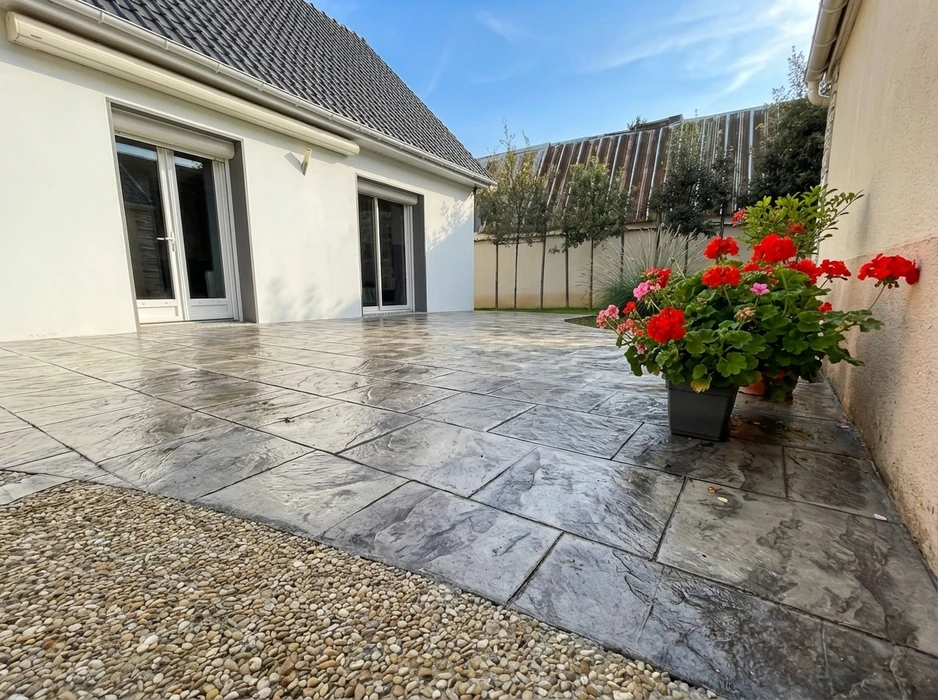Terrasse extérieure pavée en béton imprimé gris marbré, motif grand format irrégulier, aspect poli et lustré