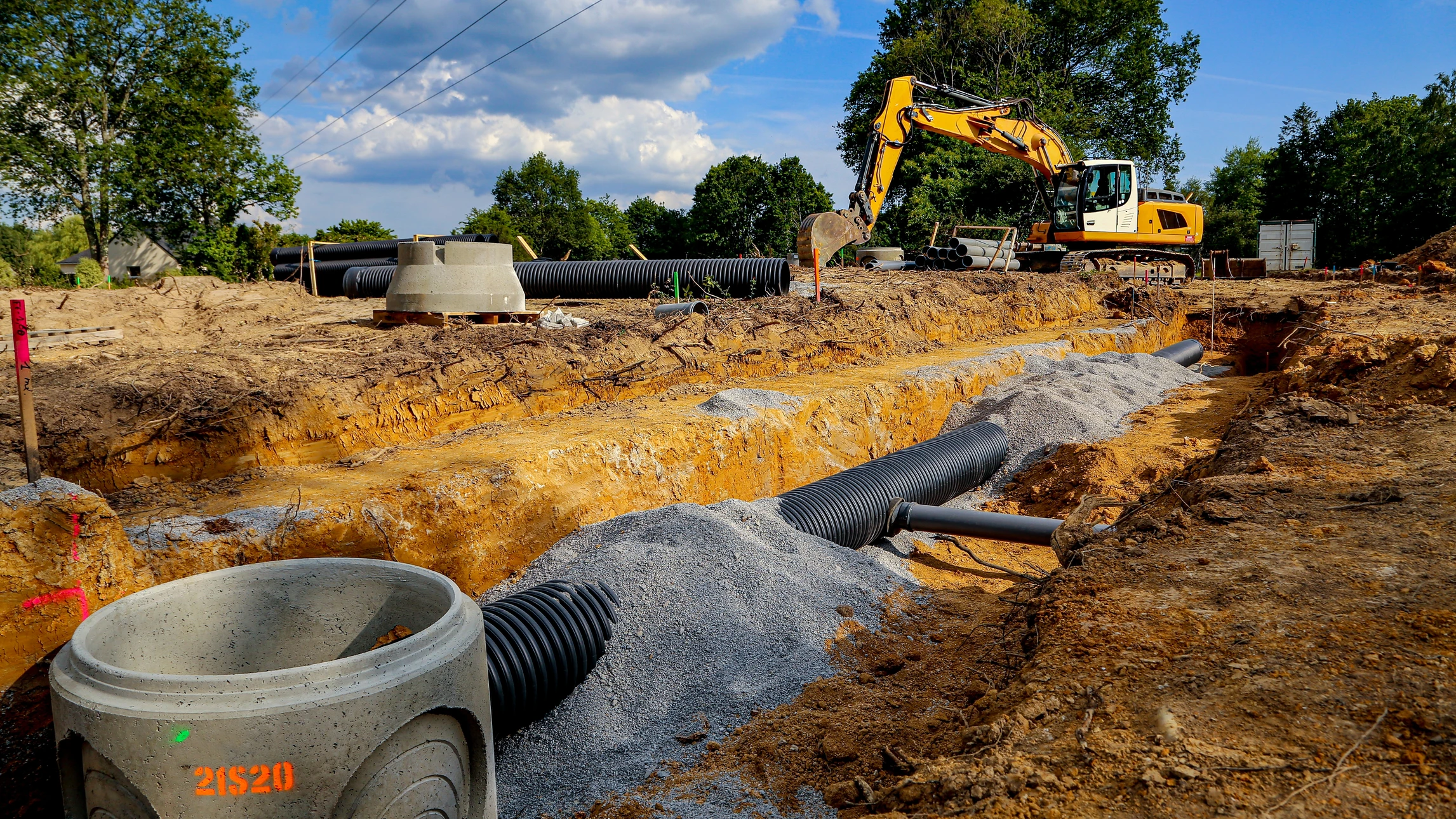 Chantier extérieur d'installation d'assainissement avec fosse septique cylindrique noire en polyéthylène posée sur dalle béton